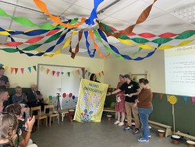 Mitglieder des Elternbeirats überreichten eine Jubiläums-Fahne an Elvira Terhorst.