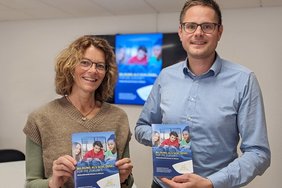 Dieses Foto zeigt Anke Gövert und Ralf Frerick aus der Abteilung „Schule und Sport“ mit der neuen Broschüre