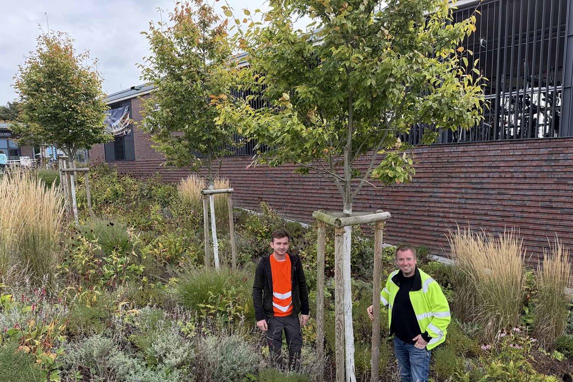 Dieses Foto zeigt Christian Fränzer (r.) und Fin Hanning vor einem Baum am Bahnhof