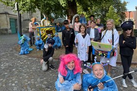 Mit selbstgebastelten Kostümen und Requisiten präsentieren die Kinder des Theater-Projektes am Freitagnachmittag ihr Stück auf dem Kirchplatz. Foto: Stadt Dülmen/Kannacher