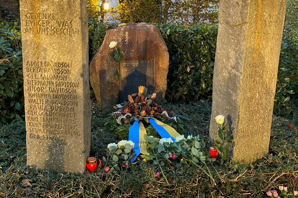 Kranz und weiße Rosen vor dem Denkmal am jüdischen Friedhof.