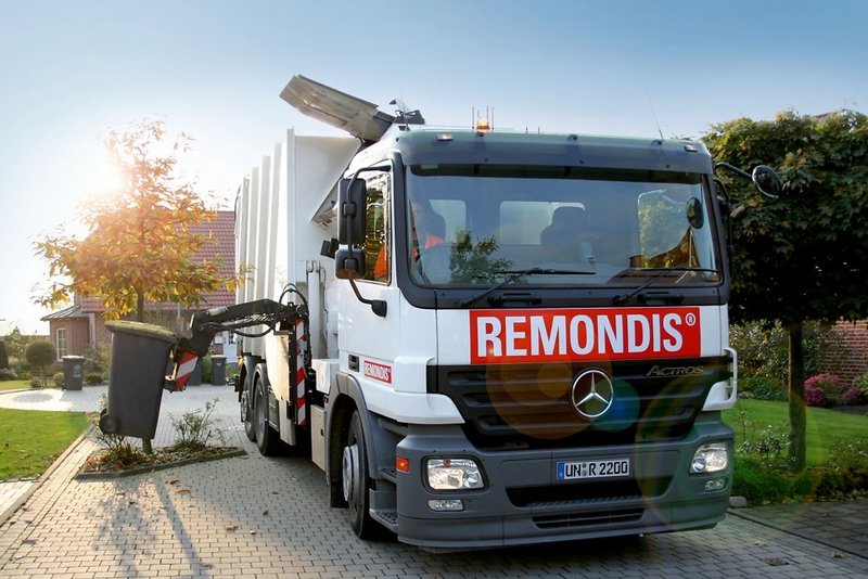 Müllwagen hebt gelbe Tonne an.