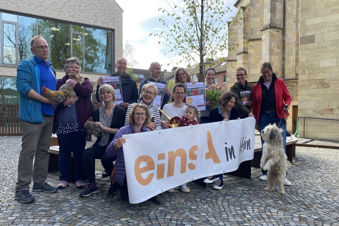 Das Bild zeigt eine Gruppe von Menschen und Tieren auf dem Kirchplatz.