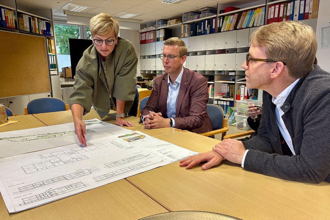 Dieses Foto zeigt Britta Sawicki, Carsten Hövekamp und Marc Henrichmann beim Studieren der Neubaupläne. 