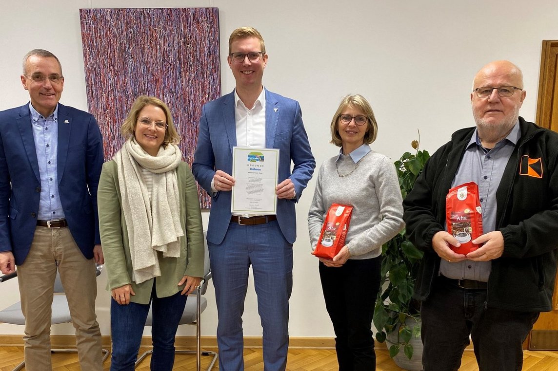 Bürgermeister Carsten Hövekamp (Mitte), Elvira Lipp (2.v. re.) und Helmut Tissen (re.) vom EineWeltLaden freuen sich gemeinsam mit Fachbereichsleiter Klaus Ricker und der künftigen VHS-Leiterin Dr. Maria Hologa über die neue Auszeichnungsurkunde für die Stadt Dülmen als „Faire Stadt“. Foto: Stadt Dülmen/Kannacher