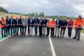Dieses Bild zeigt Verantwortliche und Partner, die das Band für den neuen Streckenabschnitt durchschneiden. 