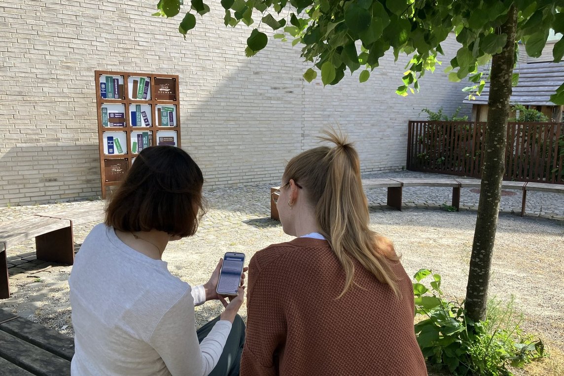 Das „Digitale Bücherregal“ und die heimeligen Sitzgelegenheiten auf dem Kirchplatz laden zum Schmökern in entspannter Atmosphäre ein. Per QR-Code werden die Texte auf dem Smartphone oder Tablet abgerufen.  Fotos: Stadt Dülmen/Kannacher 