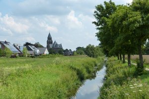 Das Bild zeigt die Umflut des Kleuterbachs und im Hintergrund die Kirche St. Georg sowie mehrere Häuser. 