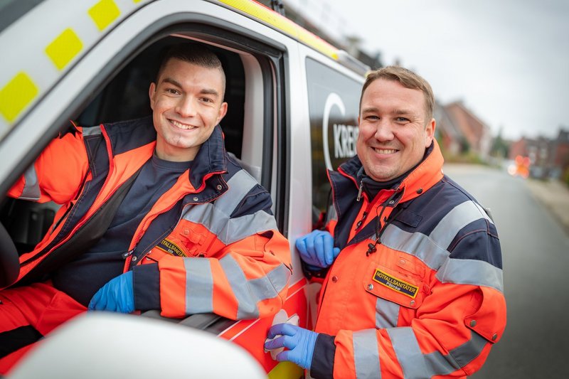 Rettungsdienst Zwei Mitarbeitende des Rettungsdienstes stehen am Rettungswagen.