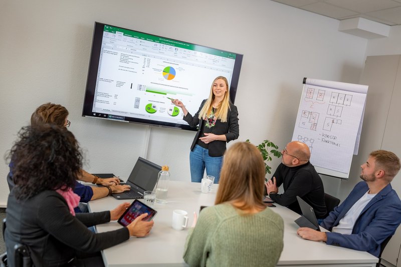 Mitarbeitende sitzen an einem Besprechungstisch.