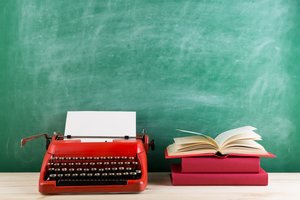 vintage typewriter and books on the table with blank paper on wooden desk
