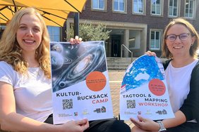 Dieses Foto zeigt Melina Rudde (l.) und Silke Althoff mit dem Plakaten für den Kulturrucksack. 
