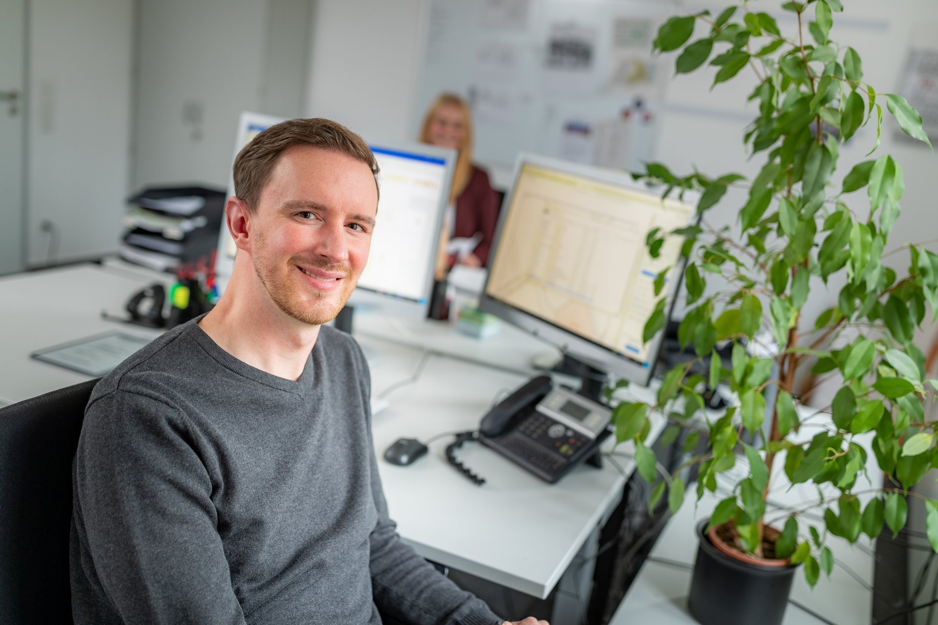 Mitarbeiter sitzt am Schreibtisch vor einem Computer.