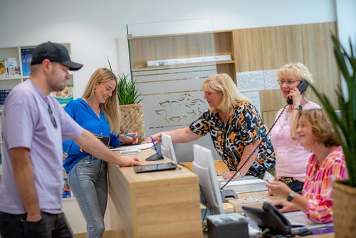 Mehrere Menschen stehen an der Infothek des Bürgerbüros.