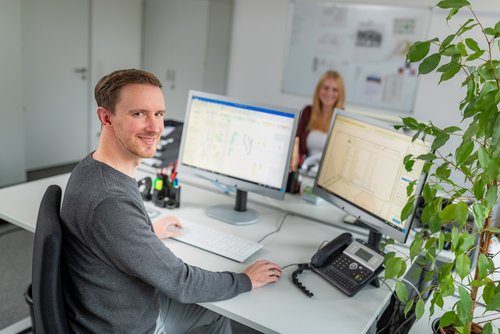 Mitarbeiter sitzt am Schreibtisch vor einem Computer.