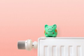 heating costs, green piggy bank on heating radiator