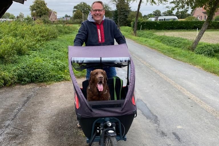 Markus Große Hülsewiesche mit Labrador Charly auf dem Lastenrad.