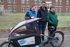 Simon Kramer vom Fachbereich Stadtentwicklung (Mitte) übergab das Lastenrad an Mitarbeitende der Alexianer Werkstätten. Foto: Alexianer Werkstäten/Karin Jasper