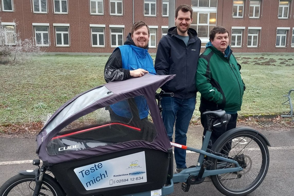 Simon Kramer vom Fachbereich Stadtentwicklung (Mitte) übergab das Lastenrad an Mitarbeitende der Alexianer Werkstätten. Foto: Alexianer Werkstäten/Karin Jasper